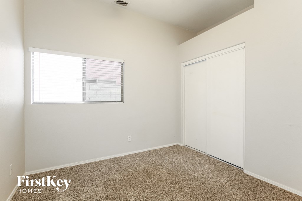 a bedroom with white walls and a window and a door