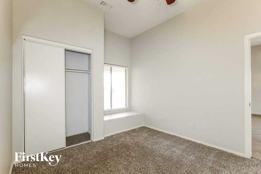 a bedroom with white walls and a window and a closet