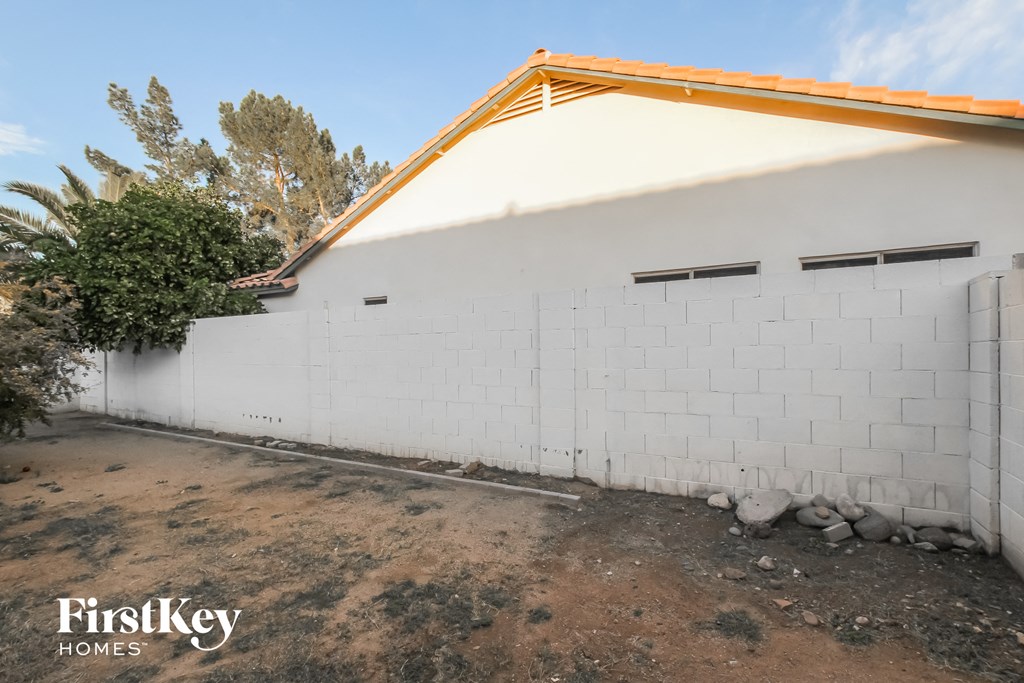 the side of a house with a white wall and a orange roof