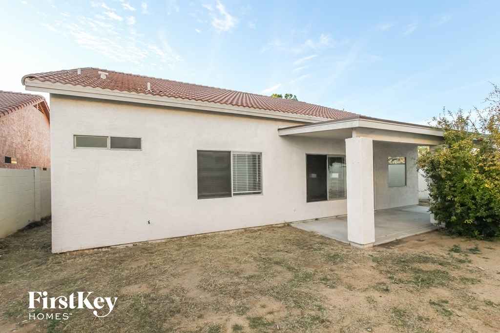 a small white house with a yard and a driveway
