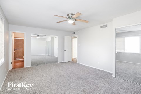 a living room with carpet and a ceiling fan