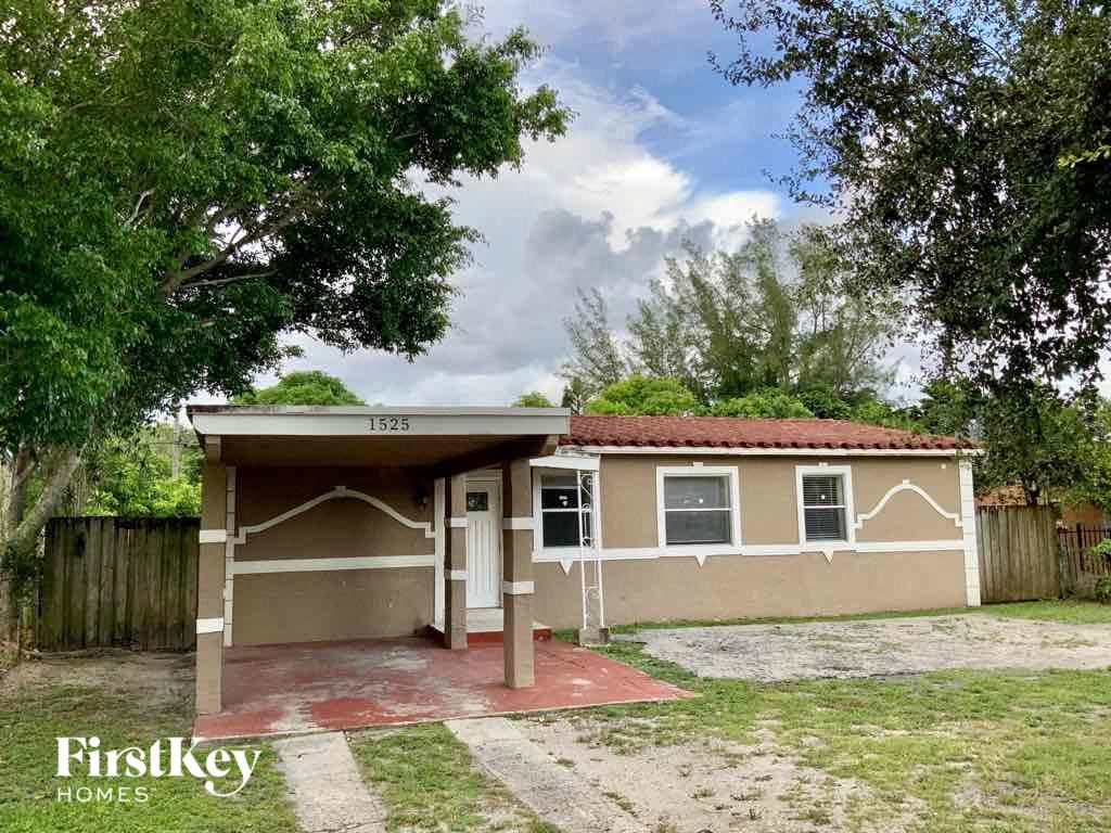 A small house with a red roof and a sign that says "Firstkey Homes" in front of it.