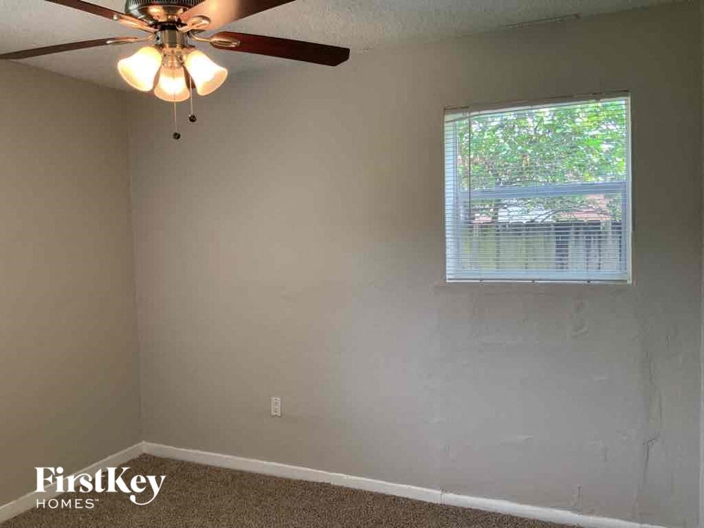 A room with a ceiling fan and a window.