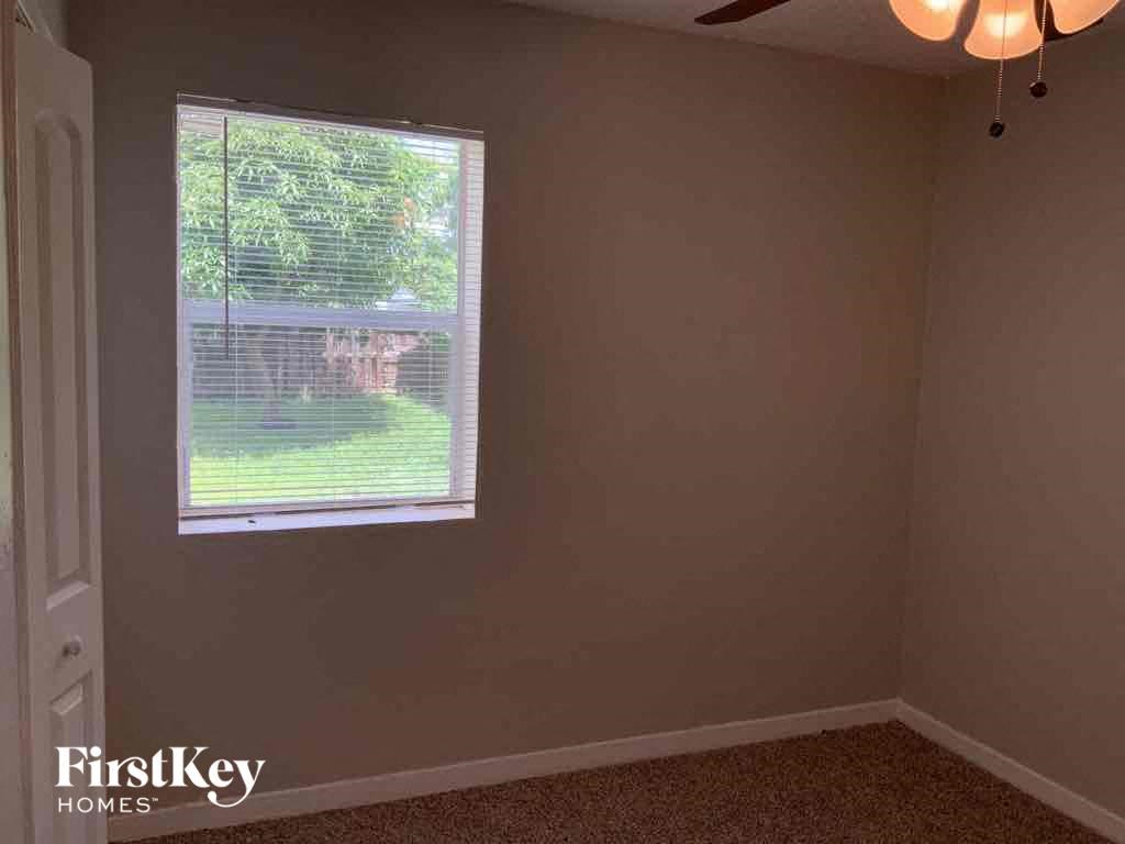 A room with a window showing a view of a backyard.