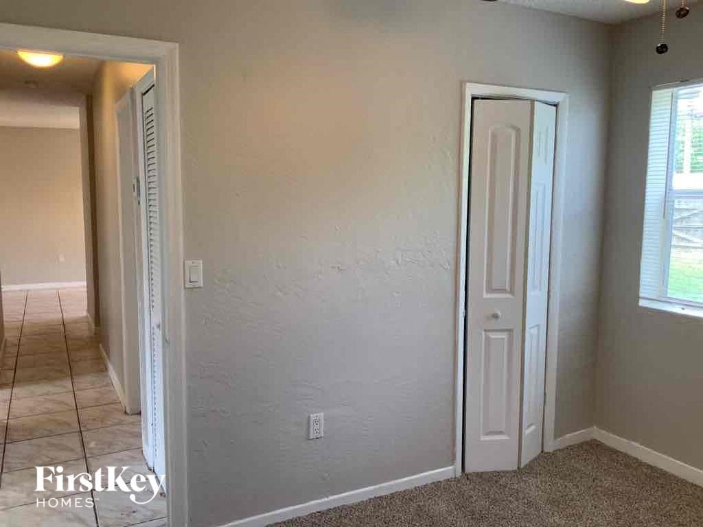 A room with a white door and a window with blinds.