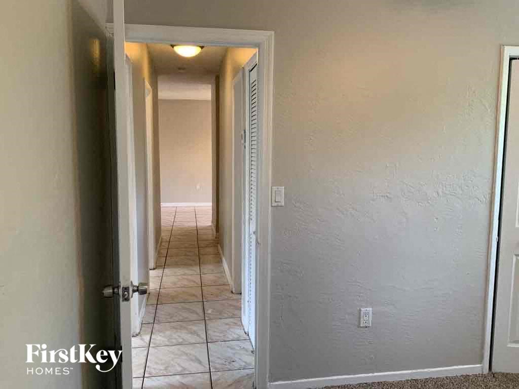 A hallway with a tile floor and white walls.
