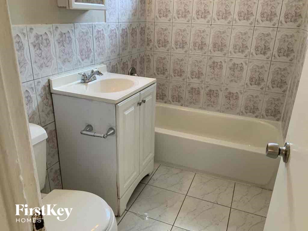 A white bathroom with a sink, toilet and bathtub.
