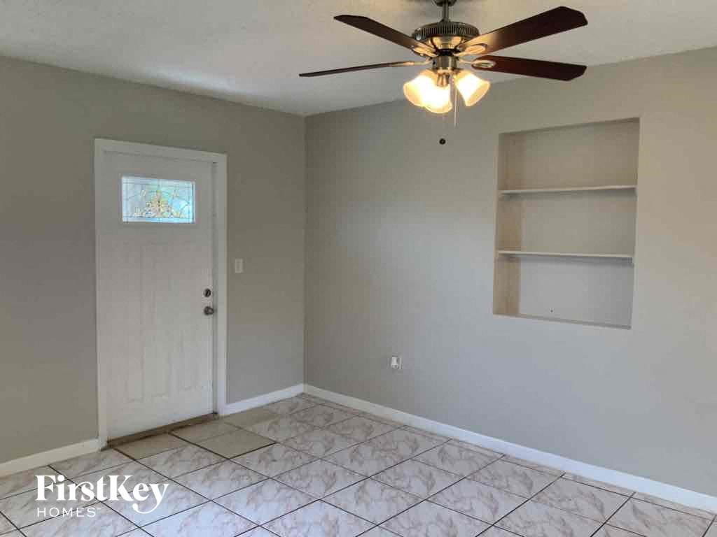 A room with a ceiling fan and a door.