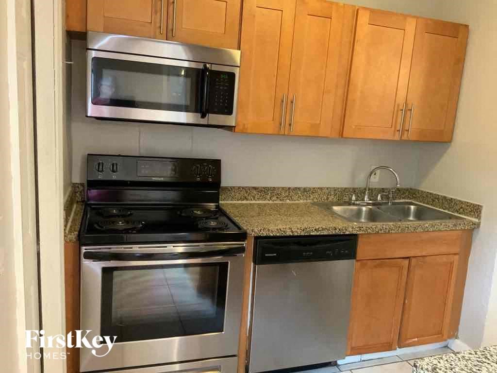 A kitchen with a stove top oven and a microwave above it.