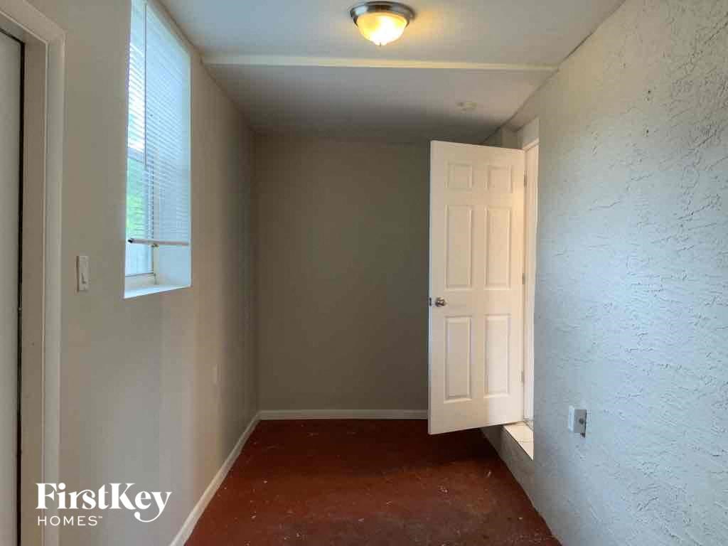 A room with a white door and a window with blinds.