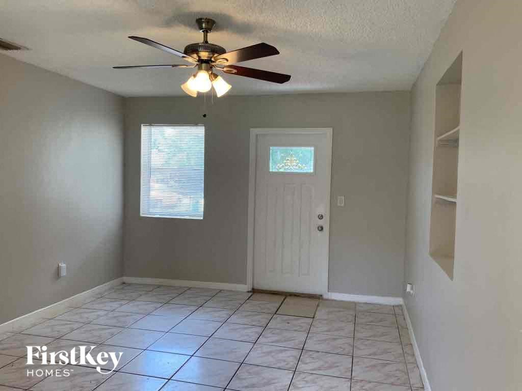 A room with a ceiling fan and a door.