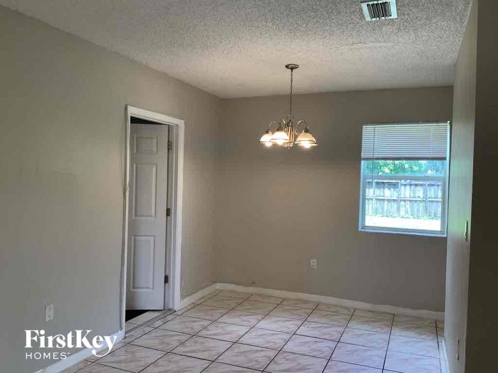A room with a door, a window, and a chandelier.