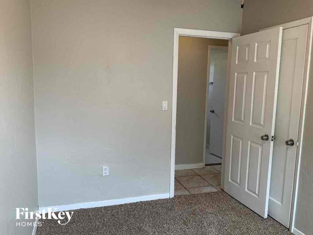A room with a white door and a carpeted floor.