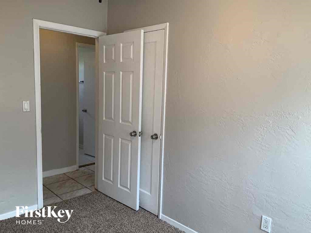 A white door is in a room with a carpet.