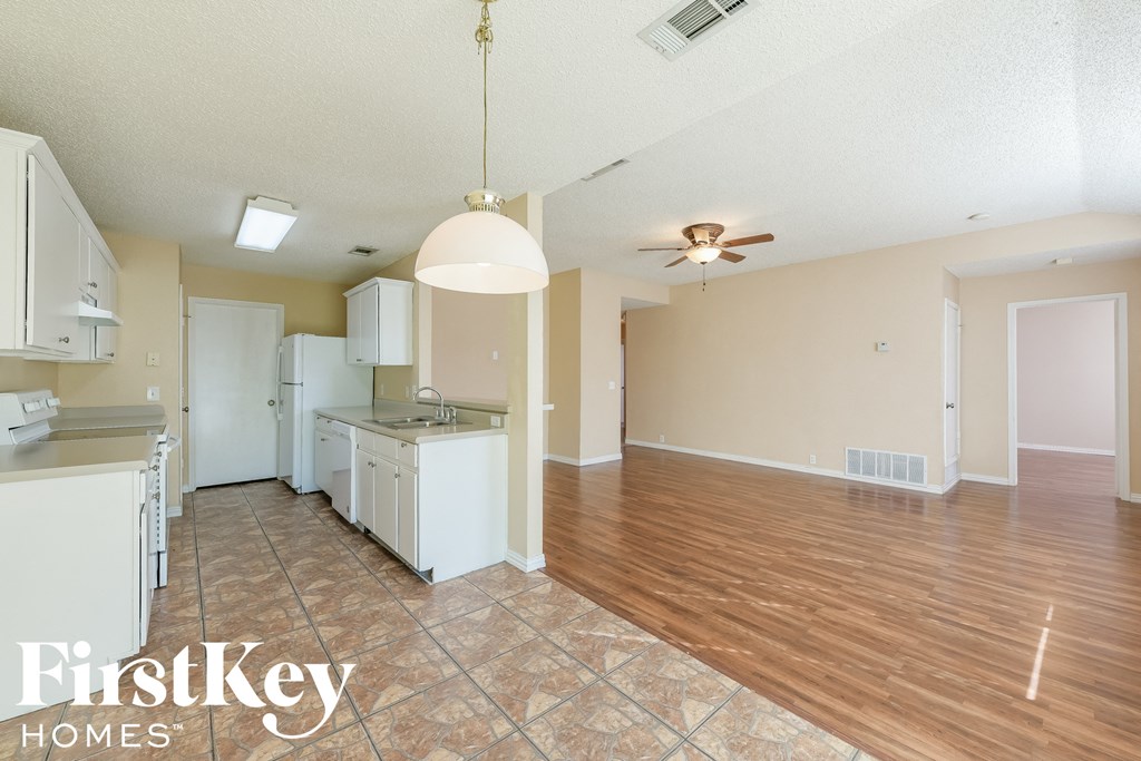 A kitchen area with a tile floor and a ceiling fan.
