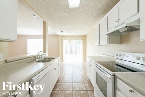 A kitchen with a stove top oven and a sink.