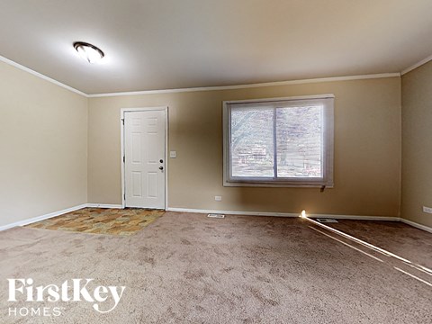A room with a carpet, a door, and a window.