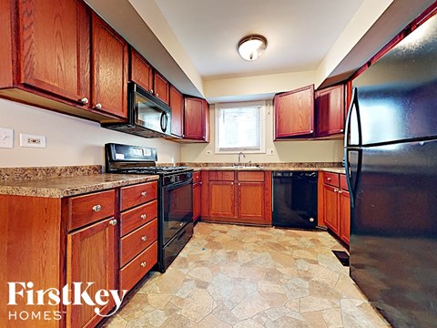 A kitchen with wooden cabinets and black appliances.