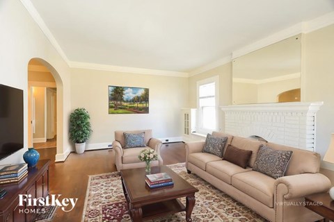 A living room with a couch, a coffee table, and a painting on the wall.
