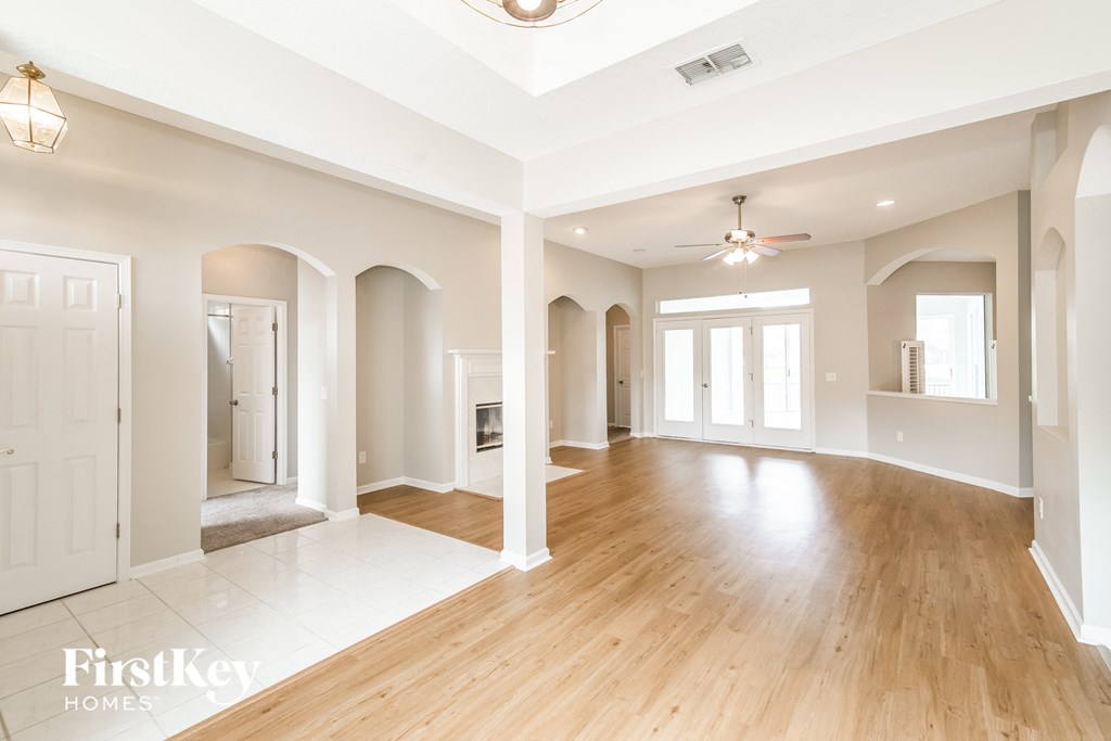 A spacious room with wooden floors and white walls.
