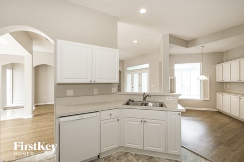 A kitchen with white cabinets and a sink.