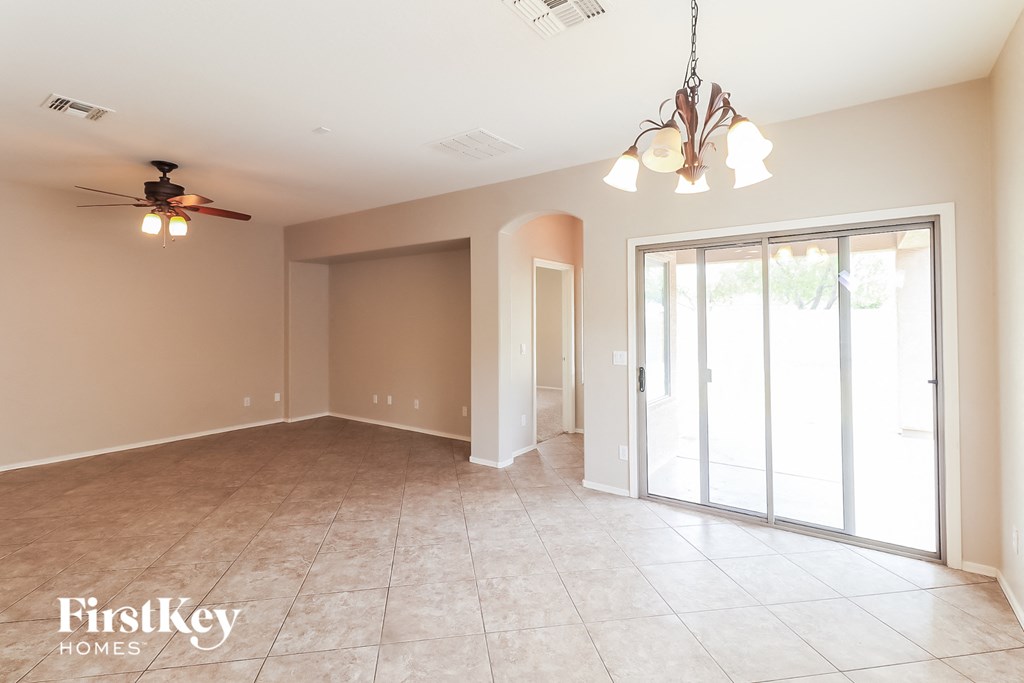 A spacious room with a ceiling fan and sliding glass doors.