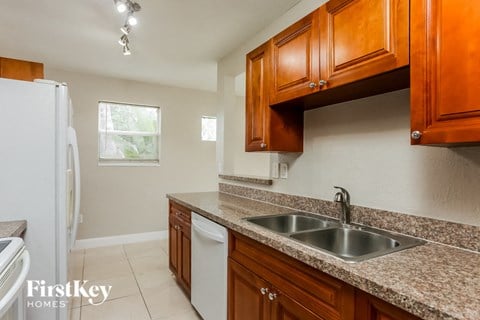 a kitchen with wooden cabinets and granite counter tops and a sink