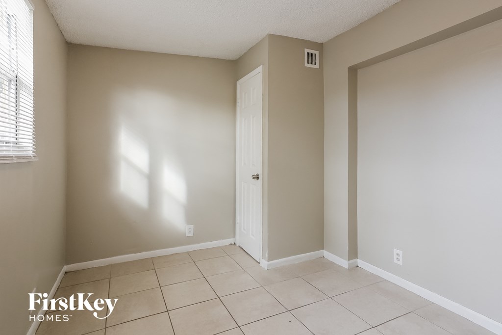 an empty room with a door and a tiled floor