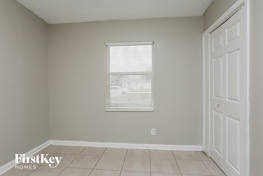 an empty room with a window and a tiled floor
