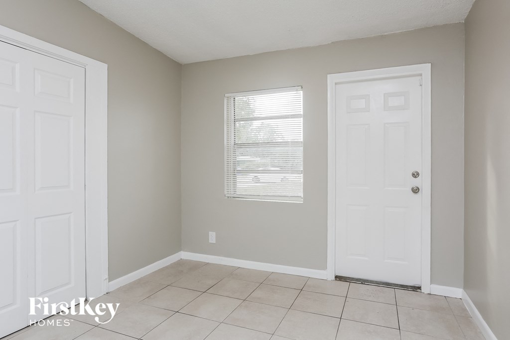 an empty room with two doors and a tiled floor
