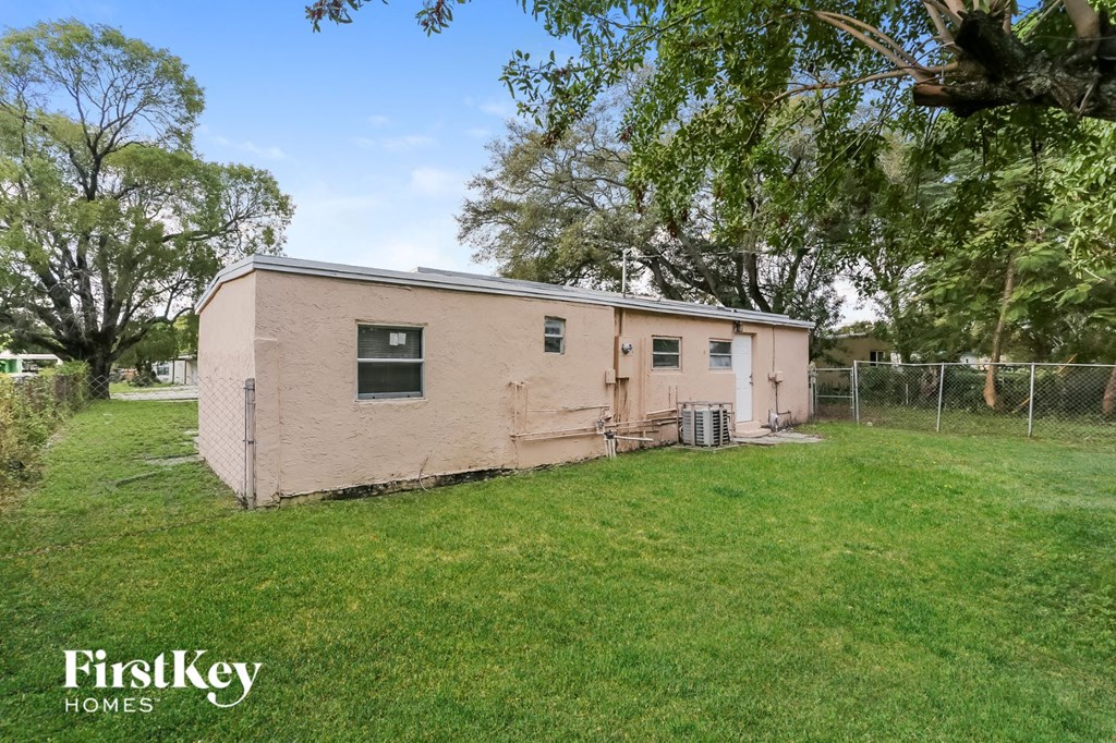 an old pink house in a yard with a fence