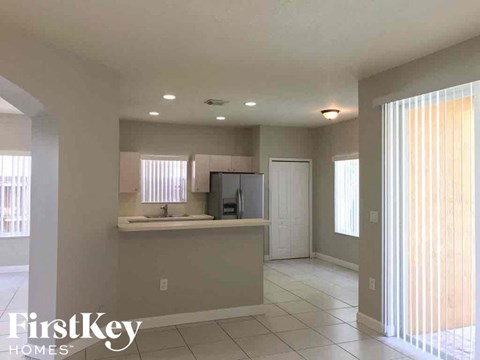A kitchen area with a sink, a refrigerator, and a television set.
