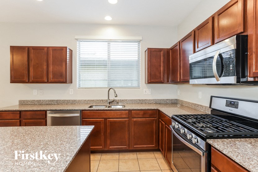 a kitchen with wood cabinets and granite counter tops