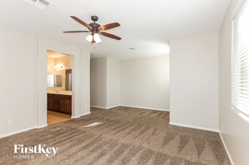 an empty living room with a ceiling fan
