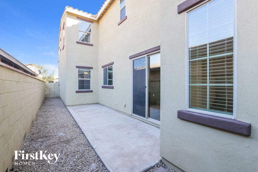 a patio in front of a white house with glass doors