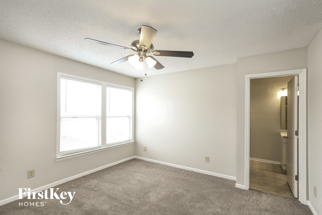 the living room of an empty house with a ceiling fan