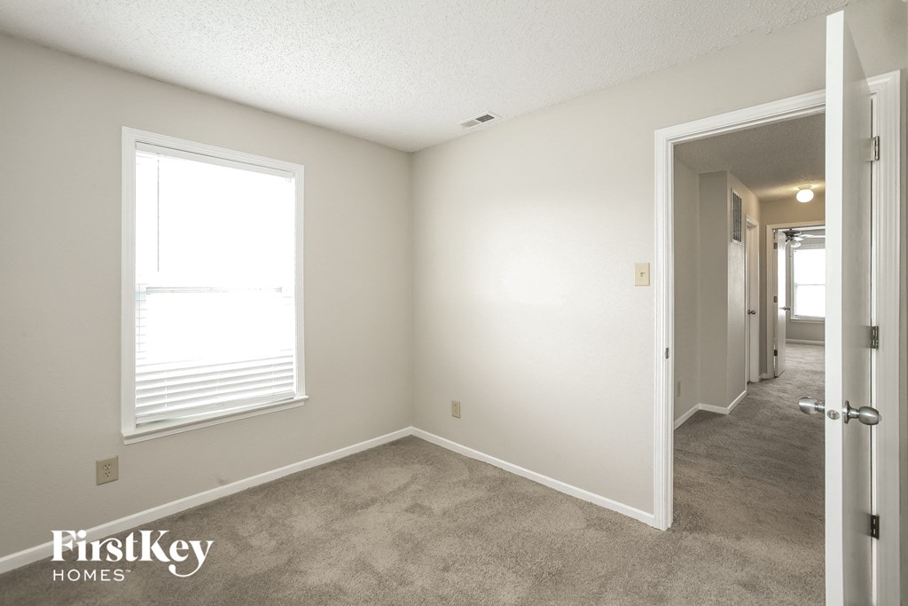 a bedroom with a carpeted floor and a large window