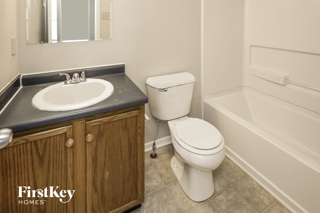 a bathroom with a toilet and a sink and a bath tub