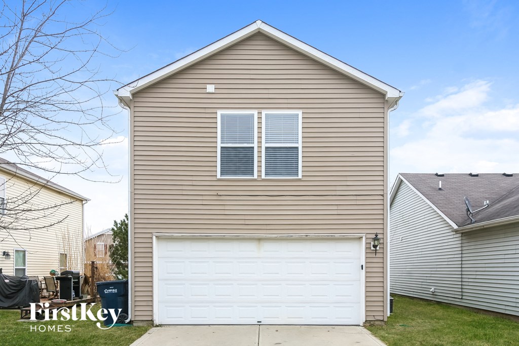 the front of a house with a white garage door
