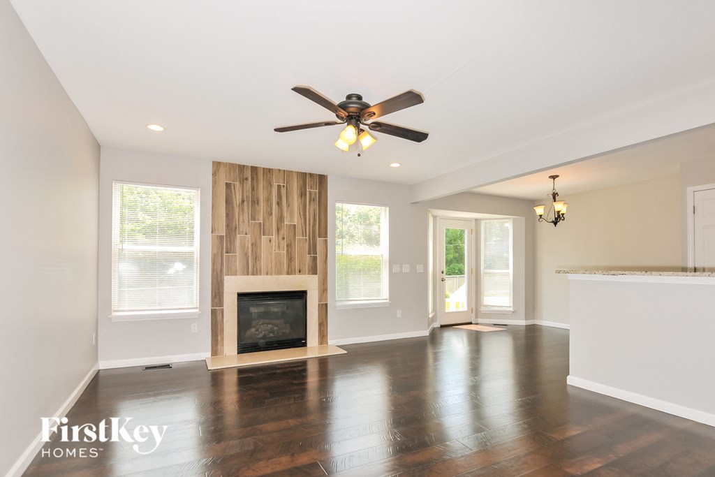 a living room with a fireplace and a ceiling fan