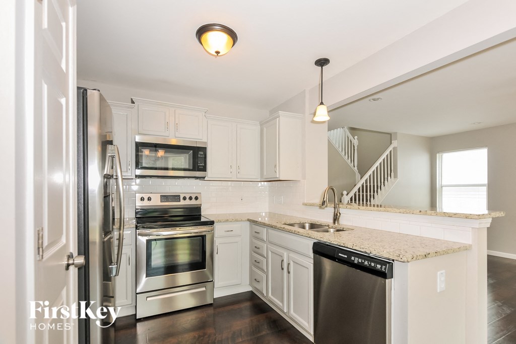 a kitchen with white cabinets and stainless steel appliances