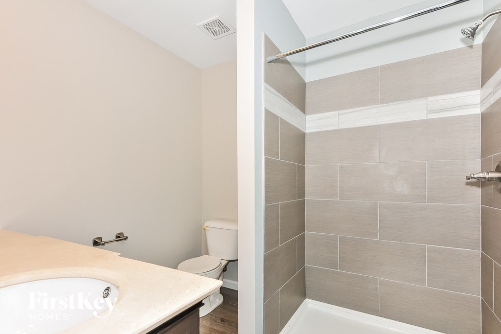 a bathroom with a shower and a sink and a toilet