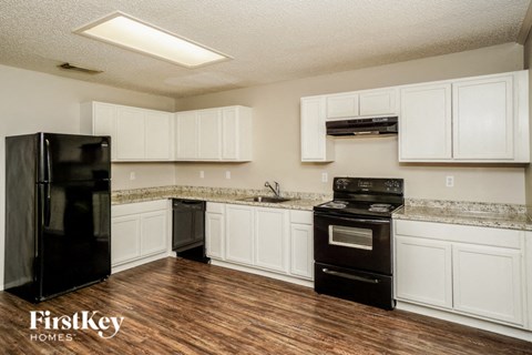 A kitchen with a black fridge and stove.