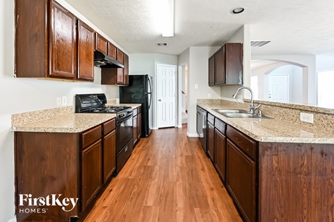 a kitchen with wood flooring and granite counter tops and