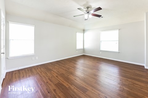 a living room with wood floors and a ceiling fan