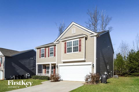 A house with a garage and a driveway in front of it.