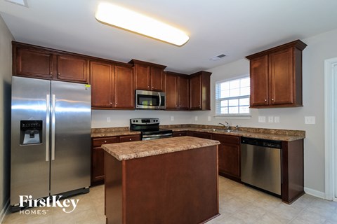 A kitchen with brown cabinets and a granite countertop.