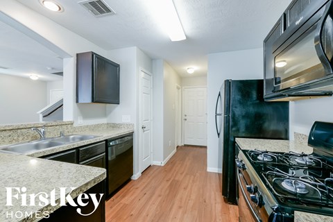 a kitchen with a stove and a refrigerator and a sink