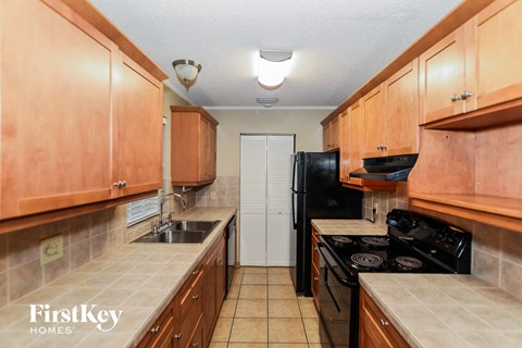 A kitchen with wooden cabinets and black appliances.