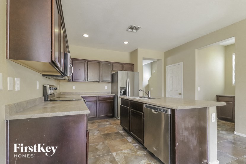 a large kitchen with stainless steel appliances and marble counter tops